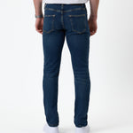 The Jeans Skinny Fit in midwash — back view worn with white sneakers