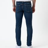 The Jeans Skinny Fit in midwash — back view worn with white sneakers