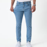 The Jeans Skinny Fit in light blue — stretching the fabric to show the flexible Motion Fabric
