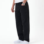 The Jeans Relaxed Straight Fit in jet black — side view worn with white sneakers