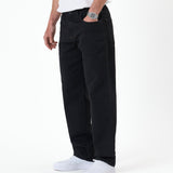 The Jeans Relaxed Straight Fit in jet black — side view worn with white sneakers