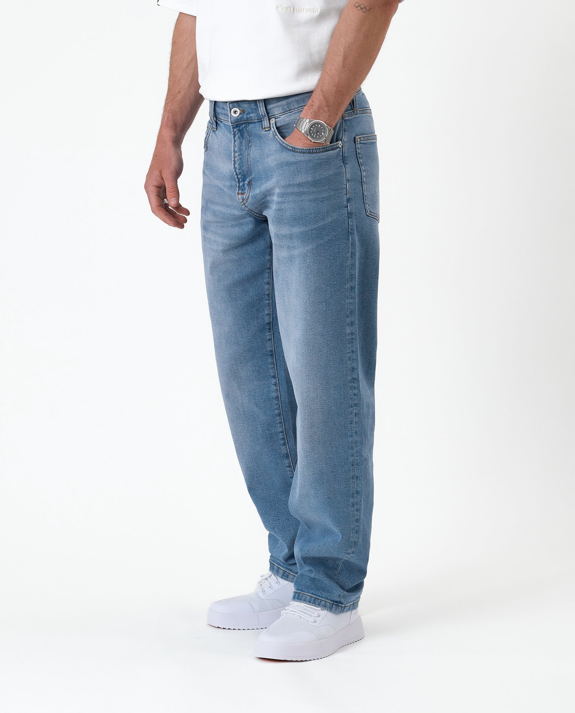 The Jeans Relaxed Straight Fit in light midwash — worn with white sneakers