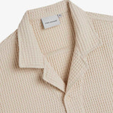 Le Waffle Resort Shirt in light beige — collar with waffle-woven texture and C'est normal tag