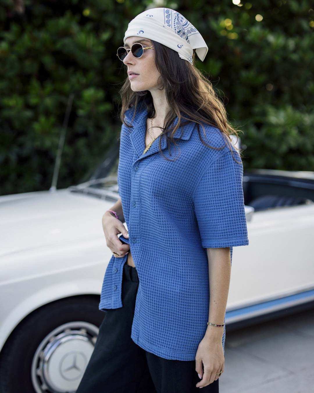 Le Waffle Resort Shirt in azure — worn with a white bandana and sunglasses next to a vintage car