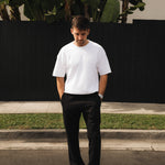 The Proper Pant Relaxed Straight Fit in black — worn with a white t-shirt and sneakers