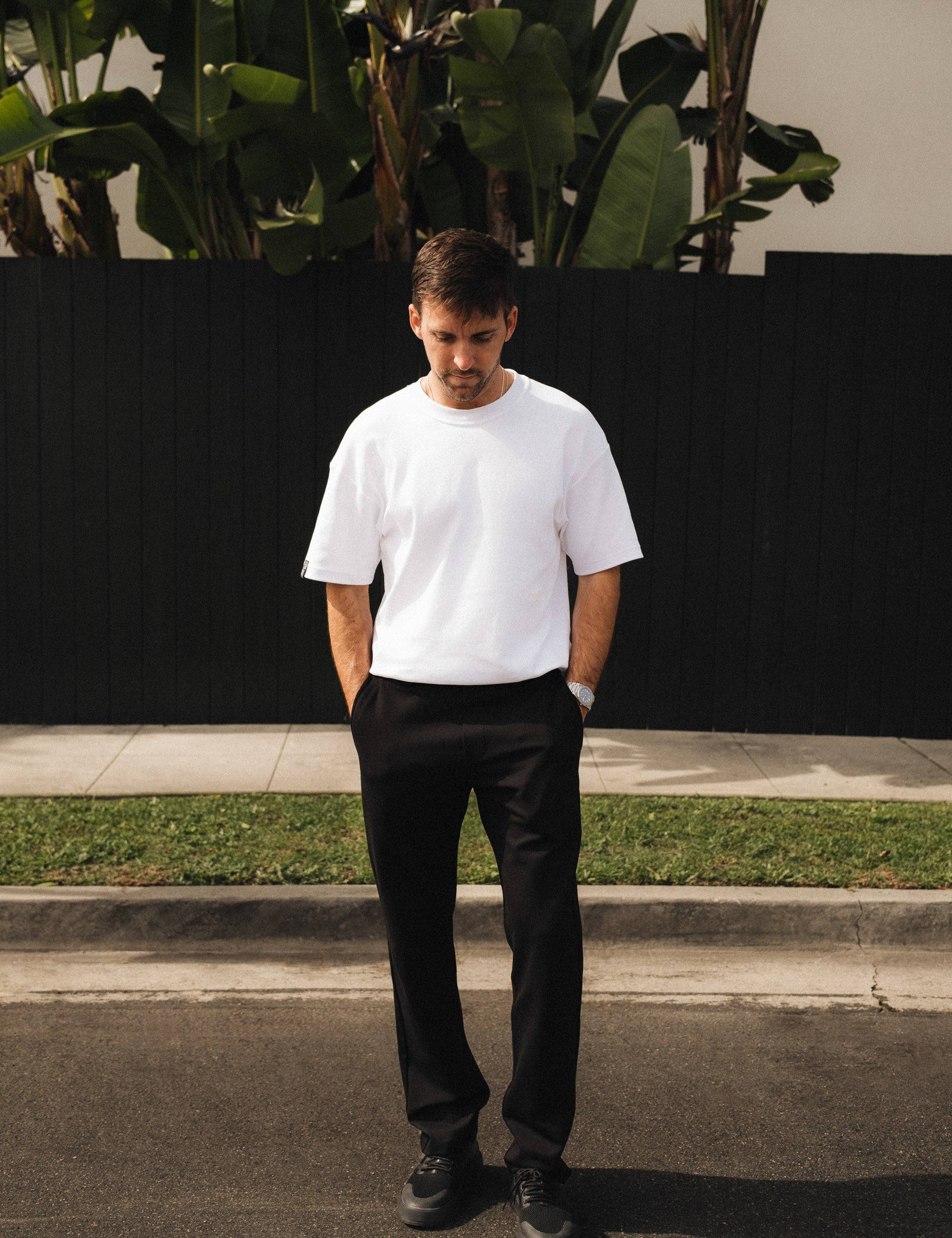 The Proper Pant Relaxed Straight Fit in black — worn with a white t-shirt and sneakers