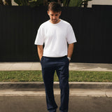 The Proper Pant Relaxed Straight Fit in navy — worn with a white t-shirt and black sneakers