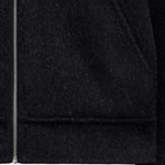 The Reversable Wool Jacket in black — close-up of the zipper and wool texture