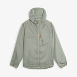 A front view of The Running Jacket in sage green, laid flat on a white background. The image highlights the hood, the front pocket with a contrast zipper puller, and the printed c'est normal logo.