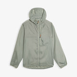 A front view of The Running Jacket in sage green, laid flat on a white background. The image highlights the hood, the front pocket with a contrast zipper puller, and the printed c'est normal logo.