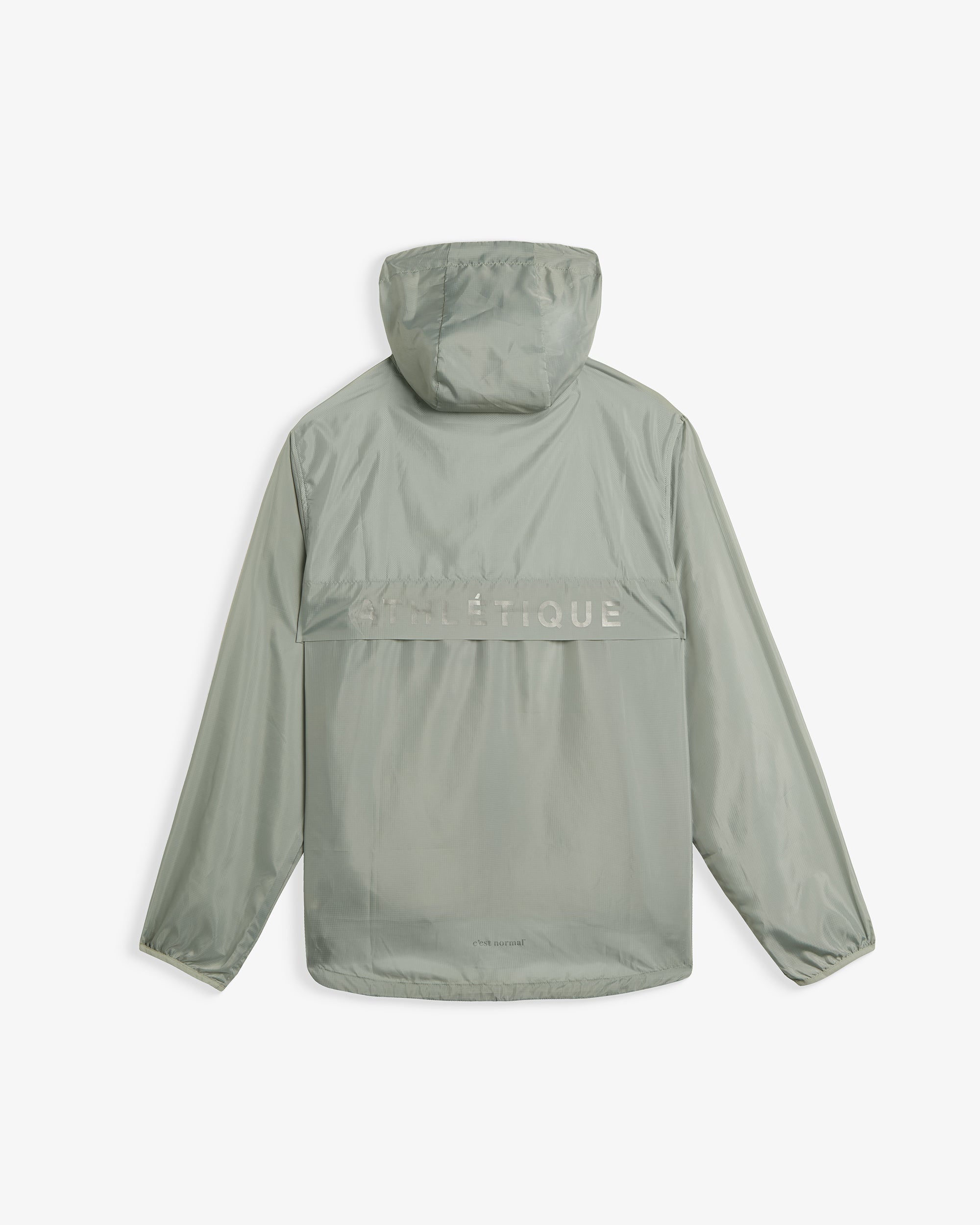 A back view of The Running Jacket in sage green, laid flat on a white background. The image highlights the hood, a back ventilation panel with reflective ATHLÉTIQUE text, and the c'est normal logo at the bottom hem.