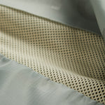 A detailed close-up of The Running Jacket in Sage Green, focusing on the interior mesh lining and back ventilation panel designed to dump heat.