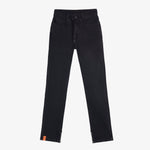 A front view of The Jeans Regular Fit in black, laid flat on a white background. The image highlights the drawstring waist, five-pocket design, ankle zippers, and the orange c'est normal label at the ankle.