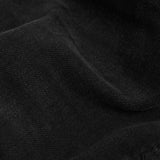 A close-up shot of the soft, broken-in black denim fabric of The Jeans Regular Fit from c'est normal.