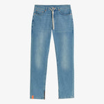 A front view of The Jeans Regular Fit in blue, laid flat on a white background. The image highlights the white drawstring waist, front pockets, ankle zippers, and a small orange c'est normal tag on the bottom hem.