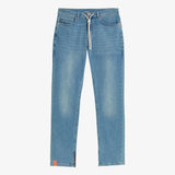 A front view of The Jeans Regular Fit in blue, laid flat on a white background. The image highlights the white drawstring waist, front pockets, ankle zippers, and a small orange c'est normal tag on the bottom hem.