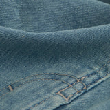 A close-up shot of the blue denim fabric of The Jeans Regular Fit, highlighting the texture and stitching details.
