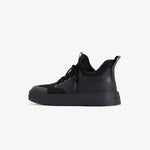 A side profile view of The Sneakers 2.0 in black on a white background. The image highlights the mesh upper, rubber accents, thick midsole, and the embossed c'est normal logo on the heel.