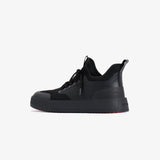 A side profile view of The Sneakers 2.0 in black on a white background. The image highlights the mesh upper, rubber accents, thick midsole, and the embossed c'est normal logo on the heel.