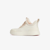 A side view of The Sneakers 2.0 in cream, laid flat on a white background. The image highlights the tone on tone mesh upper, rubber accents, and the c'est normal logo on the heel sling.