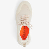 A top-down view of The Sneaker 2.0 in Cream, laid out on a white background. The image highlights the tone-on-tone mesh upper, laces, and the bright orange insole featuring the black c'est normal logo and text.