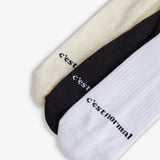 The Sock Multicolor 3-Pack in cream, black, and white — C'est normal logo across the toes