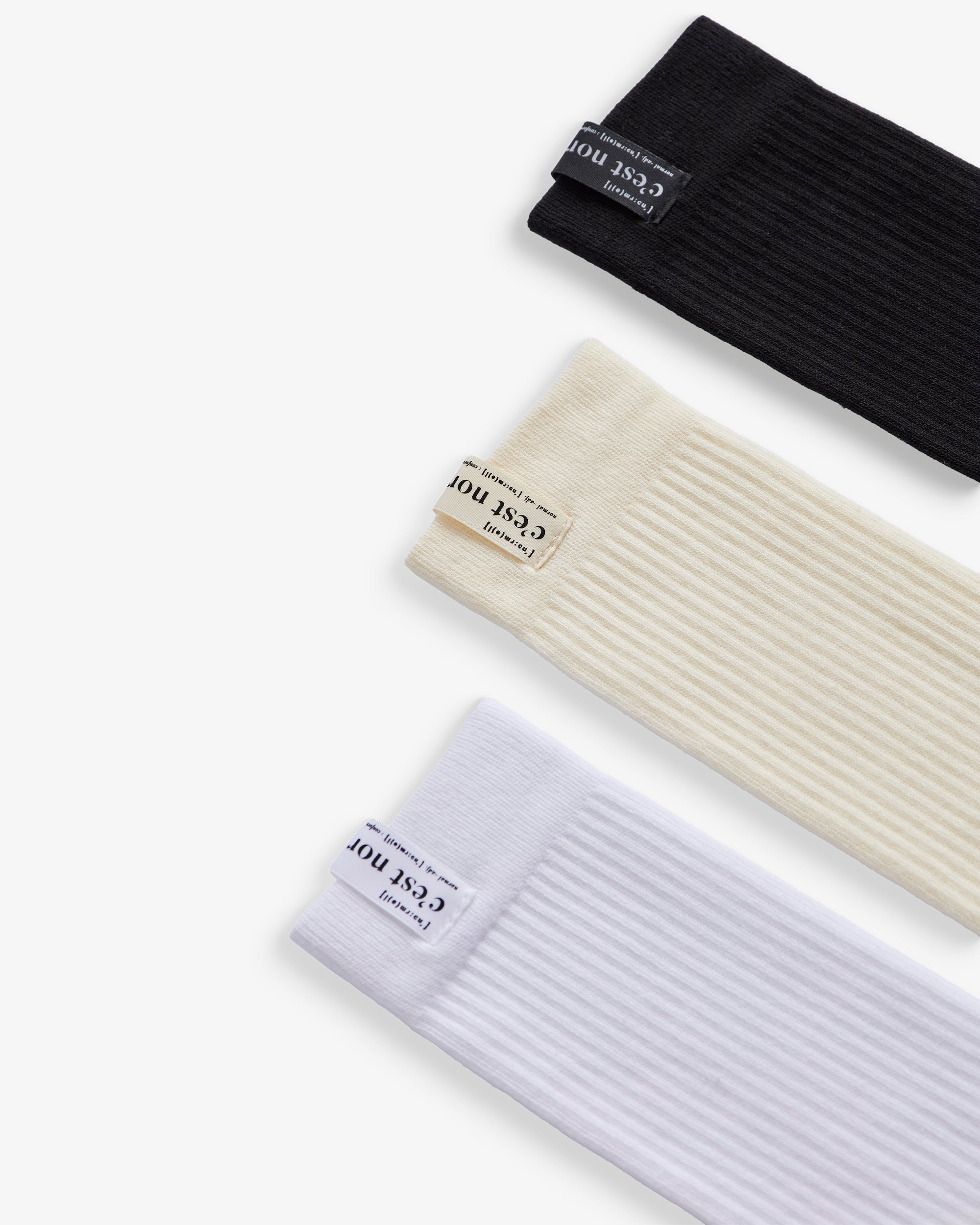 The Sock Multicolor 3-Pack in black, cream, and white — C'est normal logo on the ribbed cuffs