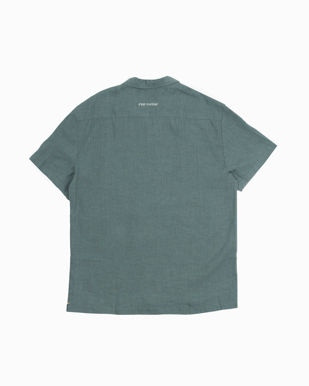 The Linen Resort Shirt in sage — back view with C'est normal embroidery on the yoke