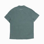 The Linen Resort Shirt in sage — back view with C'est normal embroidery on the yoke