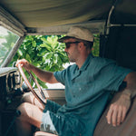 The Linen Resort Shirt in sage — worn while sitting in the driver's seat of a vintage vehicle