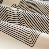 The Oversized Printed T-shirt in cream and black — close-up of the geometric line print