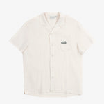 The Tampah Hills Linen Resort Shirt in cream — flat lay view with embroidered chest pocket