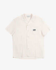The Tampah Hills Linen Resort Shirt in cream — flat lay view with embroidered chest pocket