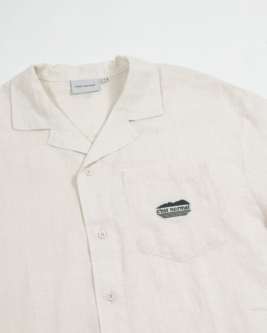 The Tampah Hills Linen Resort Shirt in cream — C'est normal logo on the chest pocket
