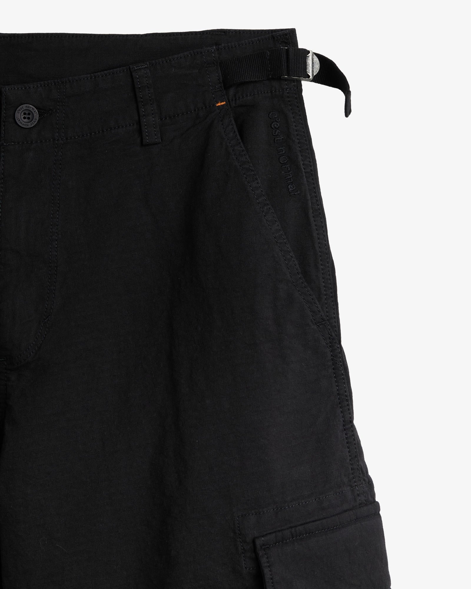 The Monterrey Cargo Pant in black — close-up of the adjustable waist and pocket embroidery