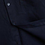 The Daily Linen Shirt in navy — close-up showing the linen texture and button placket