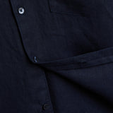 The Daily Linen Shirt in navy — close-up showing the linen texture and button placket