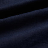 The Daily Linen Shirt in navy — close-up of the breathable 100% linen fabric texture