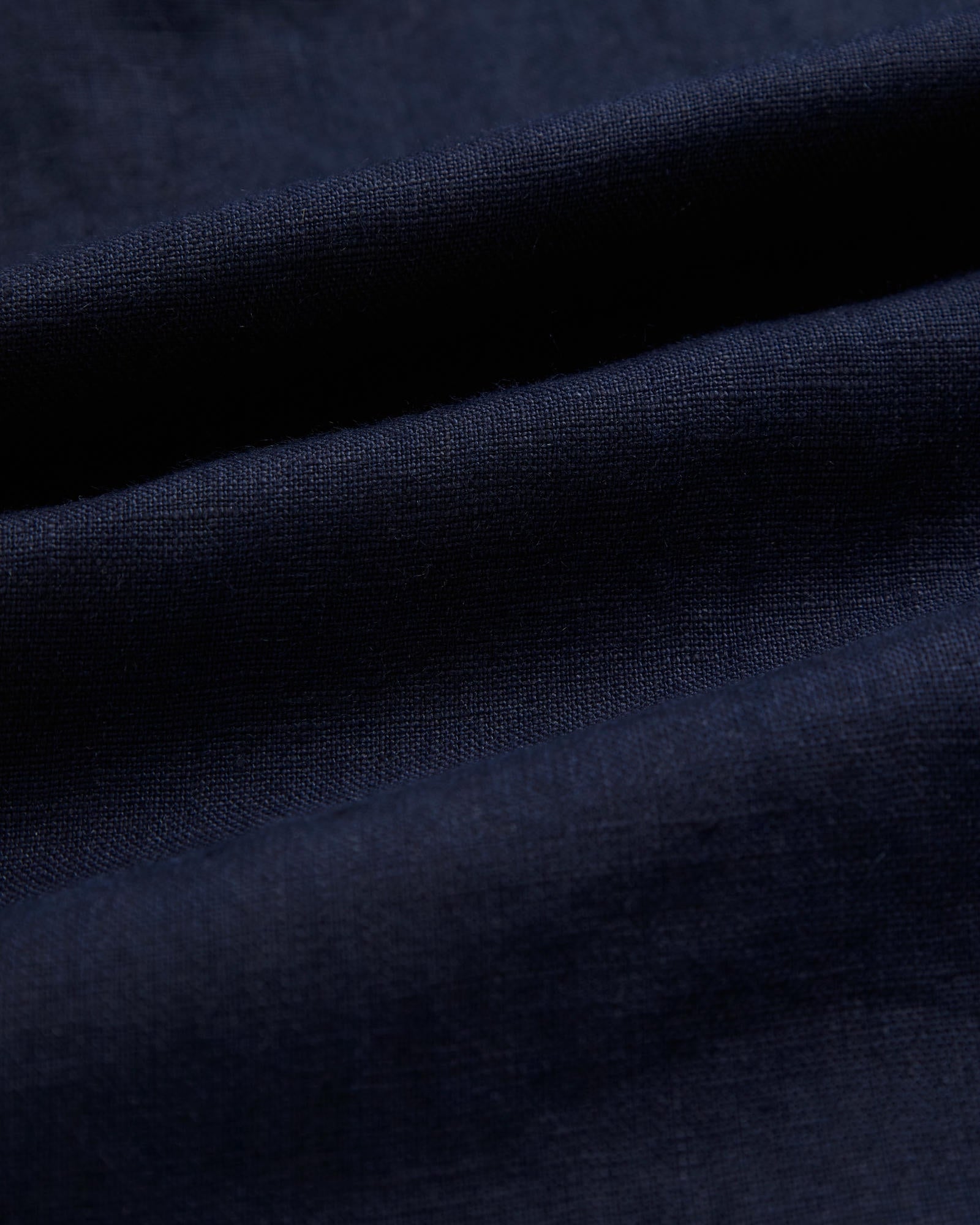 The Daily Linen Shirt in navy — close-up of the breathable 100% linen fabric texture