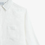 The Daily Linen Shirt in off white — close-up showing the chest pocket and tonal embroidery