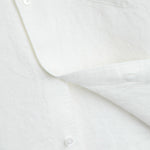 The Daily Linen Shirt in off white — close-up of the linen texture and mother of pearl buttons