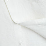The Daily Linen Shirt in off white — close-up of the linen texture and mother of pearl buttons