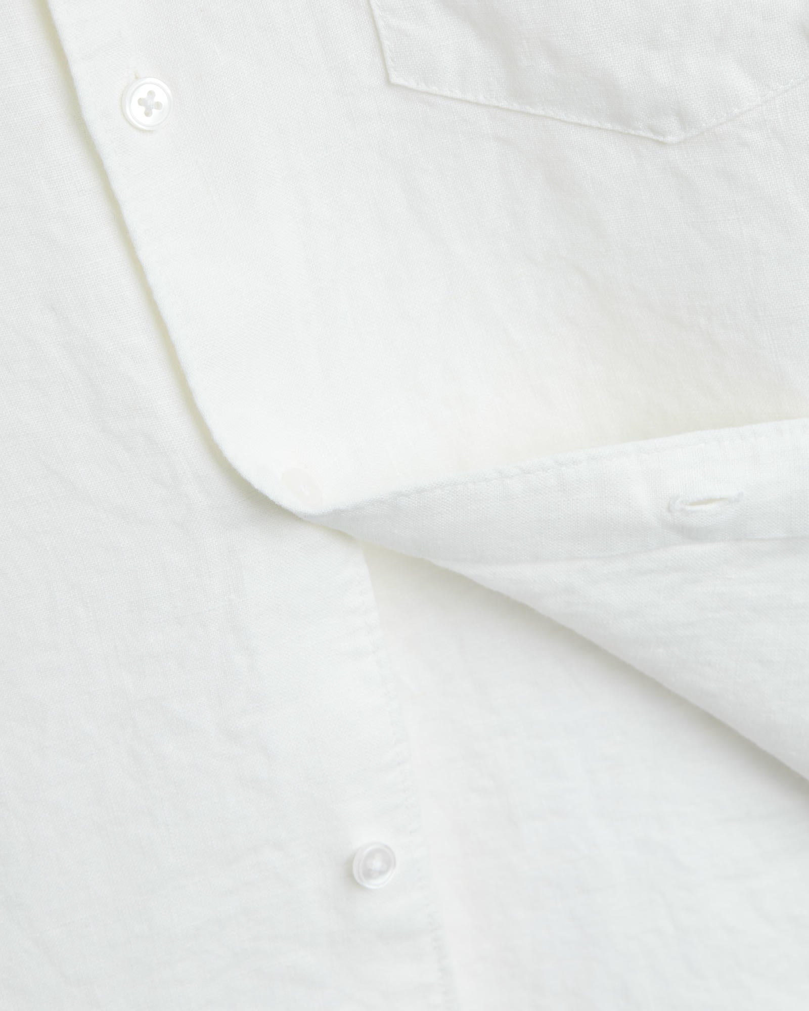 The Daily Linen Shirt in off white — close-up of the linen texture and mother of pearl buttons