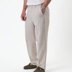 The Daily Linen Trouser in natural — front view with a pressed crease down the leg