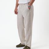 The Daily Linen Trouser in natural — front view with a pressed crease down the leg