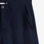 The Daily Linen Trouser in navy — close-up of the waistband and slanted front pocket