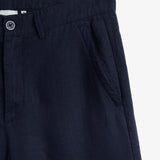The Daily Linen Trouser in navy — close-up of the waistband and slanted front pocket