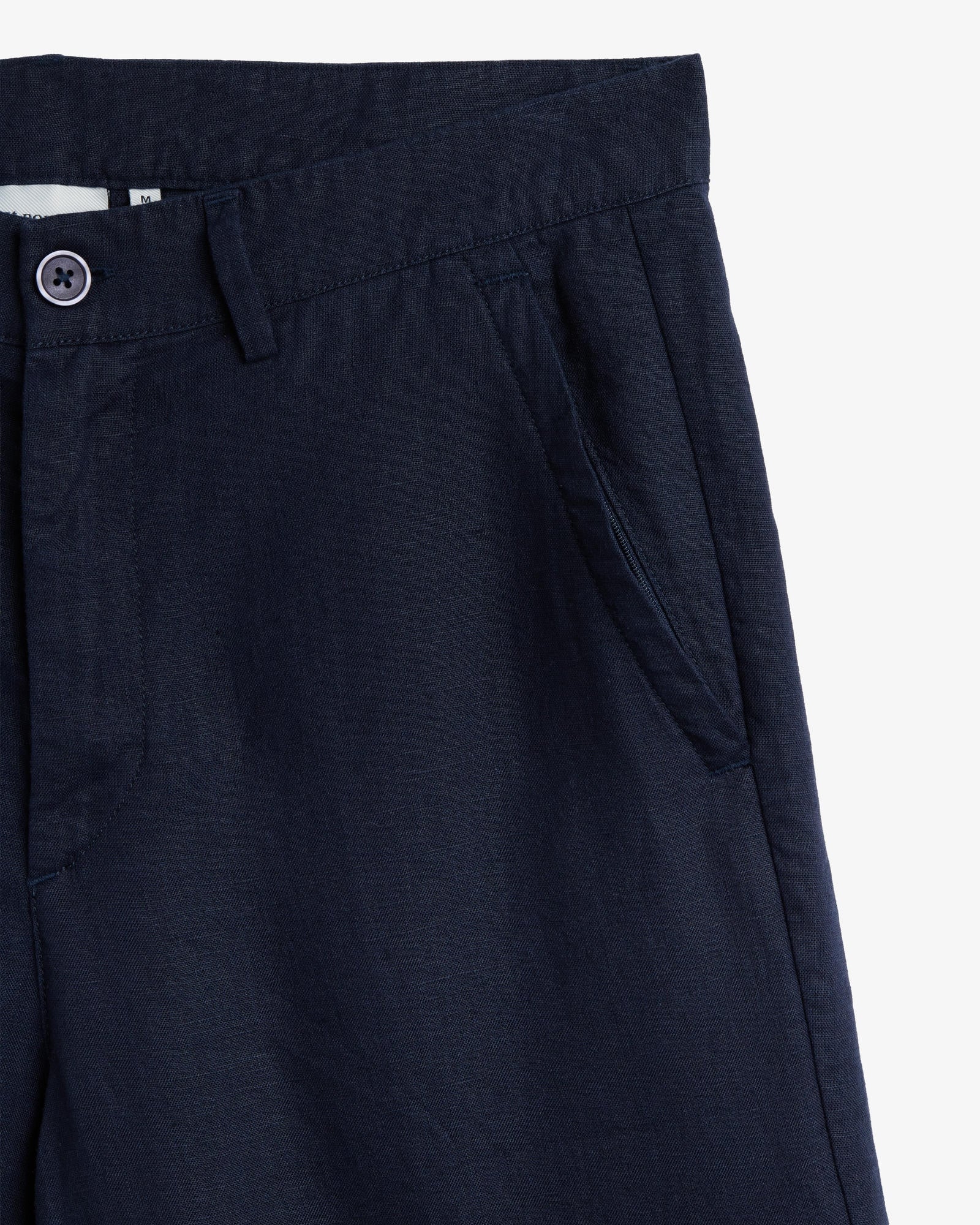 The Daily Linen Trouser in navy — close-up of the waistband and slanted front pocket