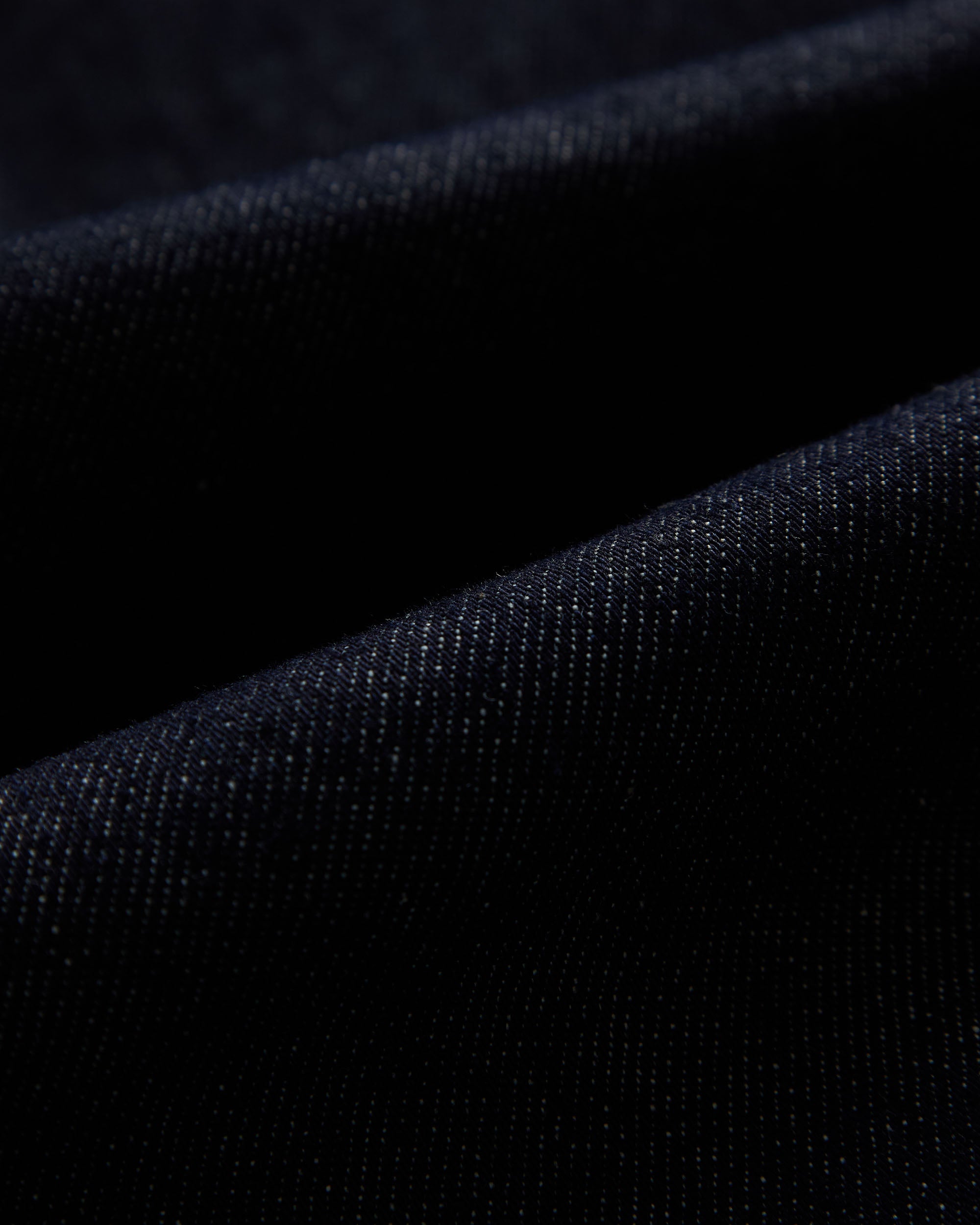 The Denim Jacket in rinse blue — close-up of the stretch motion denim fabric