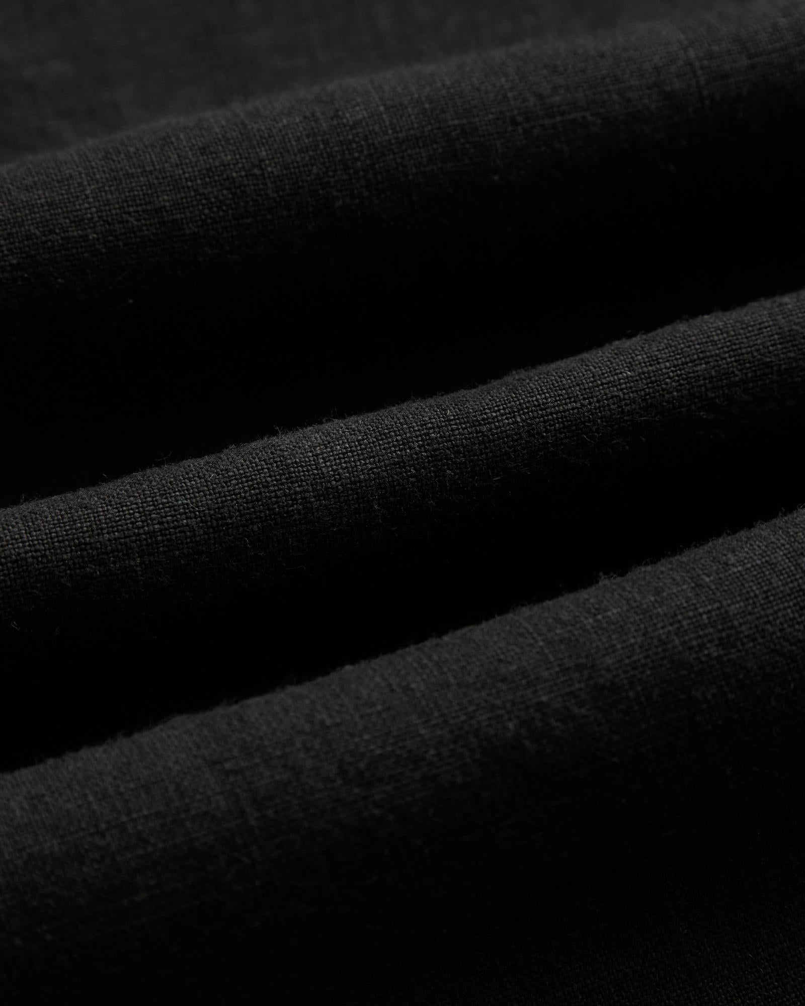 The Holiday Linen SS Shirt in black — close-up showing the breathable linen texture